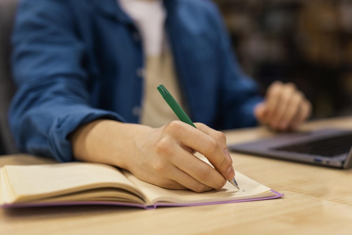 Homem estuda com caderno e lápis para concurso público 