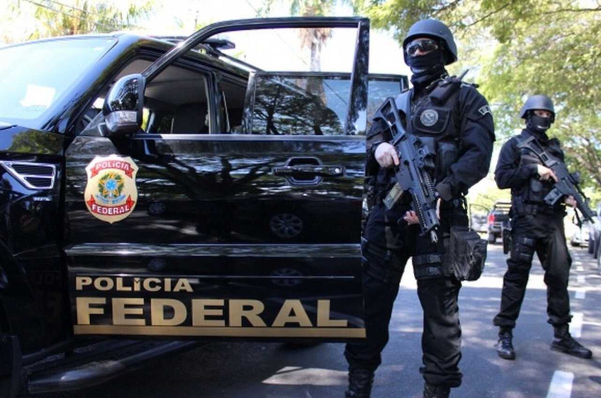 Viatura Polícia Federal com dois agentes armados e com uniformes 
