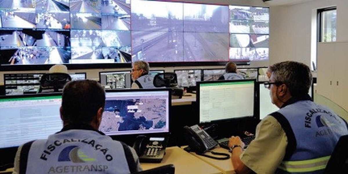 Dois agentes Agetransp analisam câmeras de segurança em sala de controle