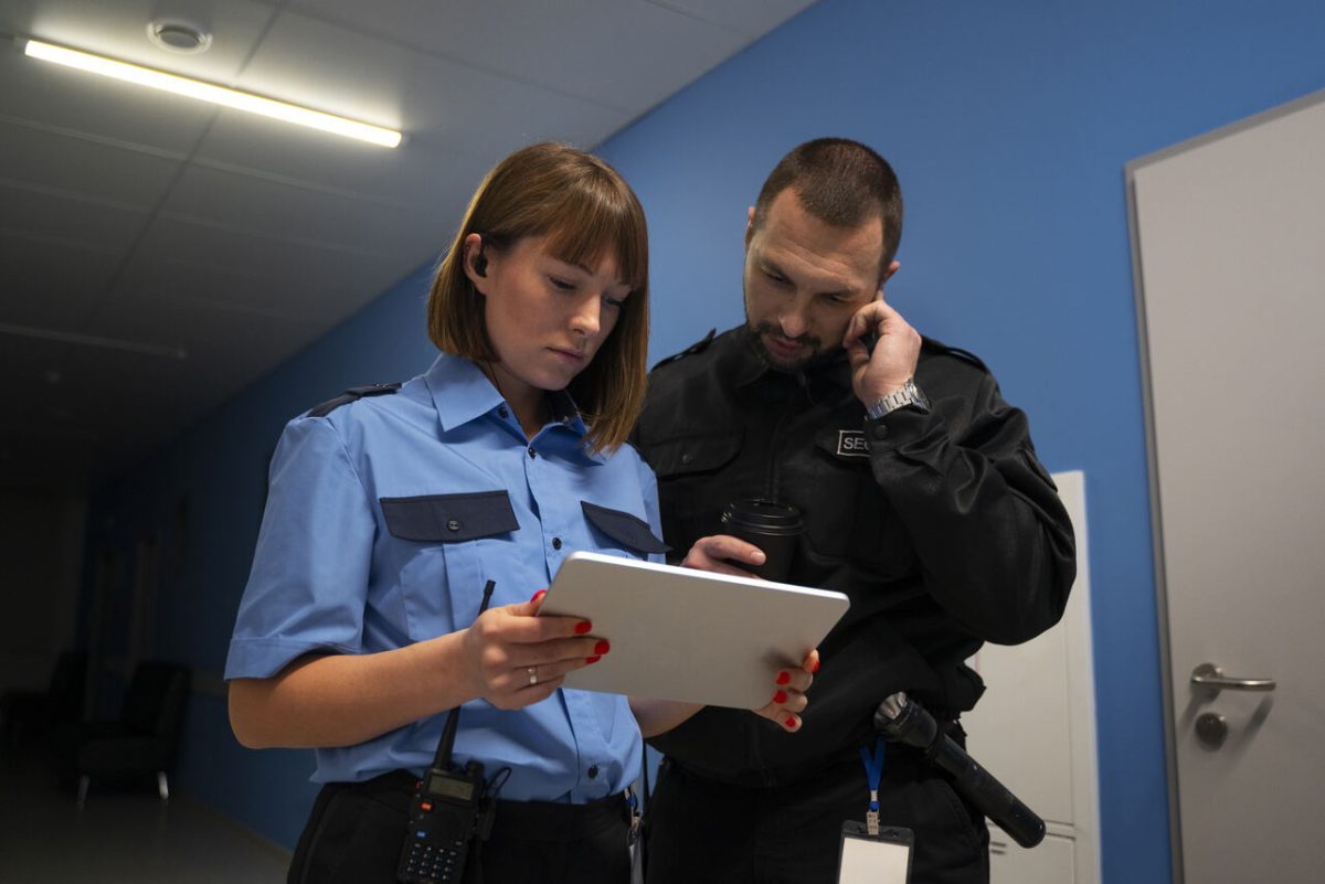 Homem e mulher policiais civis com tablet de segurança