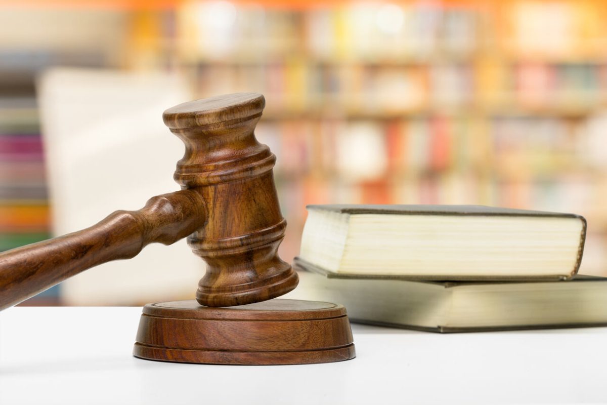 Martelo da Justiça, livros e Código Civil em biblioteca