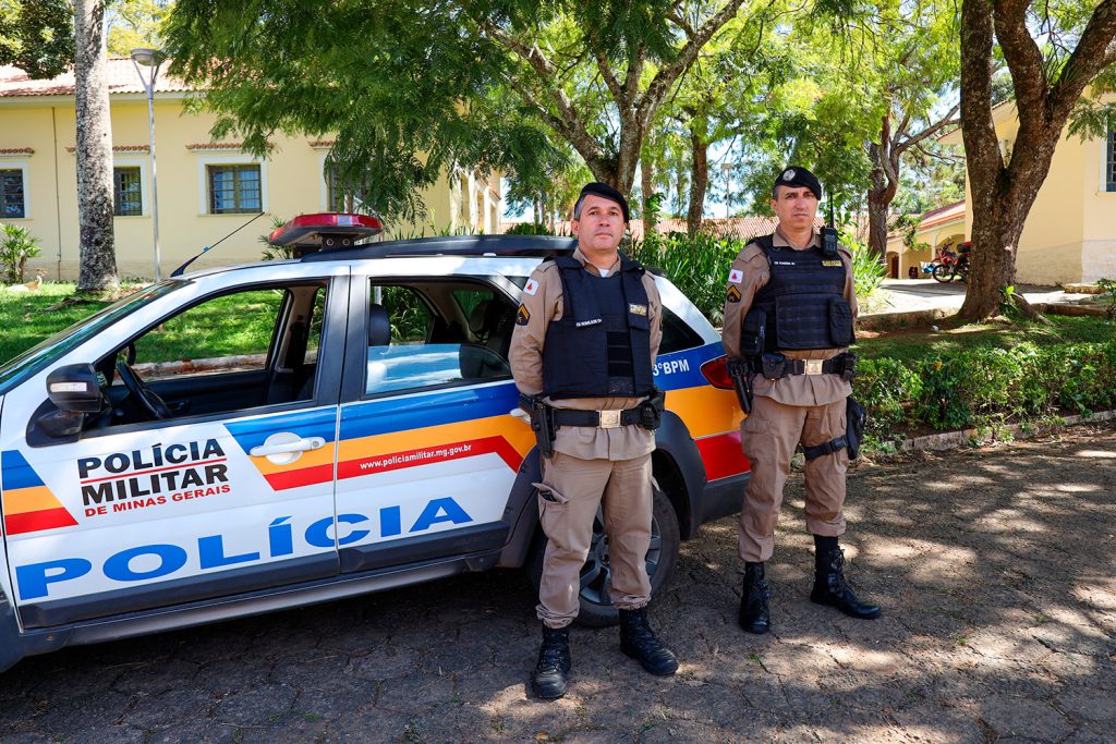 Dois policiais militares à frente da viatura da Polícia Militar de Minas Gerais