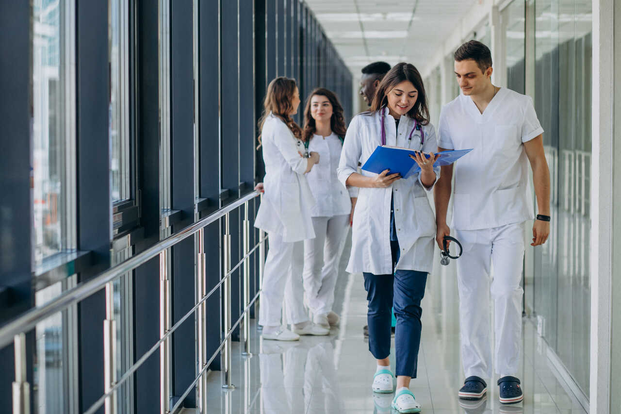 Concurso FHEMIG 2024: médicos e radiologistas em corredor de hospital com vestimentas brancas 