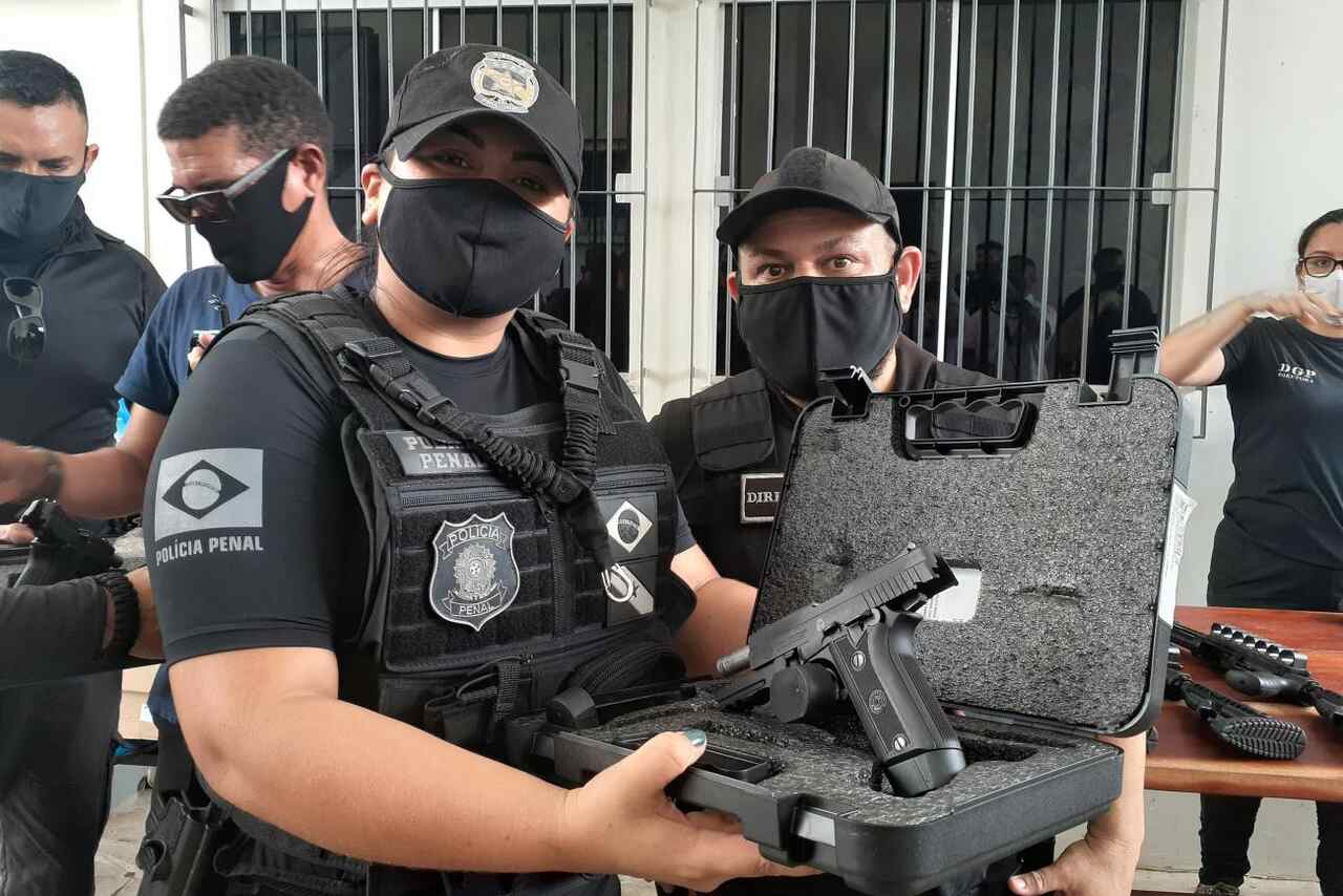 Agentes penitenciários mostram armamento bélico dentro de caixa 