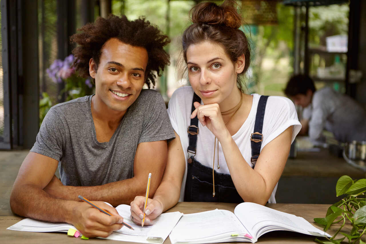 Homem e mulher estudante com lápis e cadernos 
