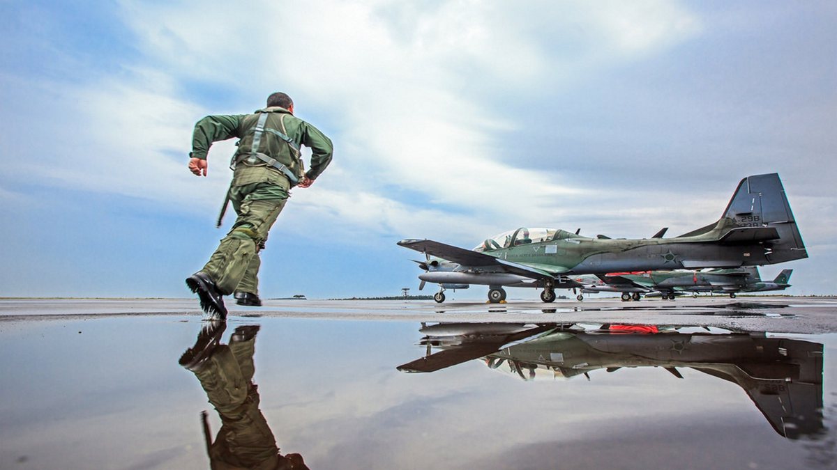 Militar da aeronáutica corre em direção a uma aeronave da FAB